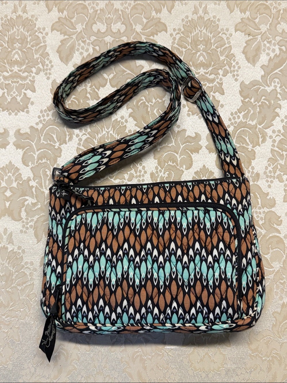 Vera Bradley Patterned Quilted Crossbody Bag in Brown, Teal, Black, and White.